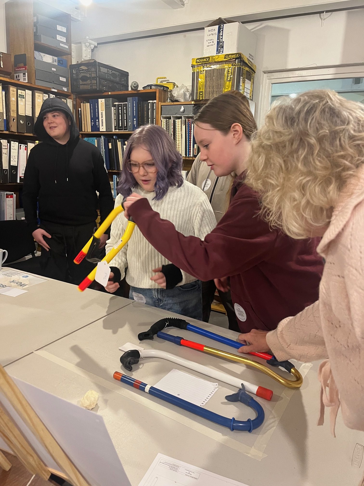 A group of people around a table with a number of brightly coloured snorkels